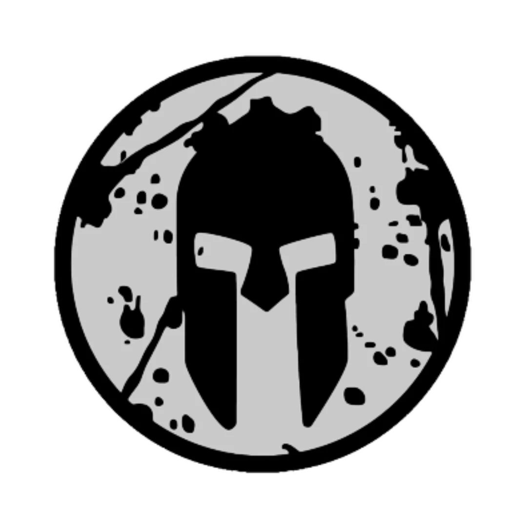 A black and gray circular logo featuring a stylized Spartan helmet, splatter marks in the background, perfect for a personal trainer or online fitness coach seeking a bold, fitness-inspired brand identity.