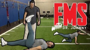 Two men demonstrate workout screening exercises on artificial turf in a gym, with large red "FMS with Dr. Johnny" text overlayed.