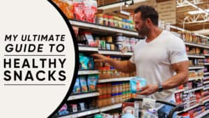 A man in a grocery store selects healthy snacks from a shelf, holding a shopping basket with various items. Text on the left reads: "My Ultimate Guide to Healthy Snacks by your online fitness coach.
